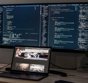 coding showing in screen and a laptop on the table