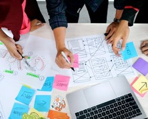 people discuss plan on the paper with laptop